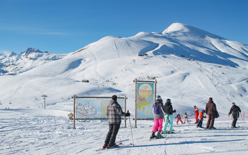 family skiing infront of mountain