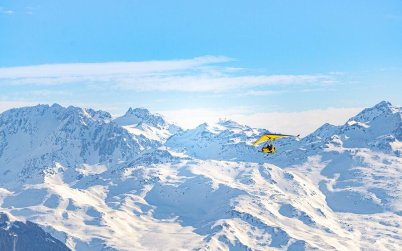 motorized hang glider flying over mountain