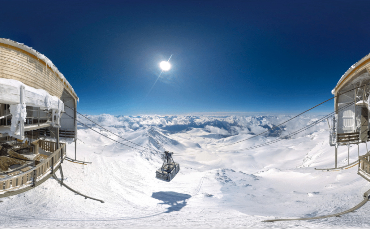 ski lift between mountains overlooking snow