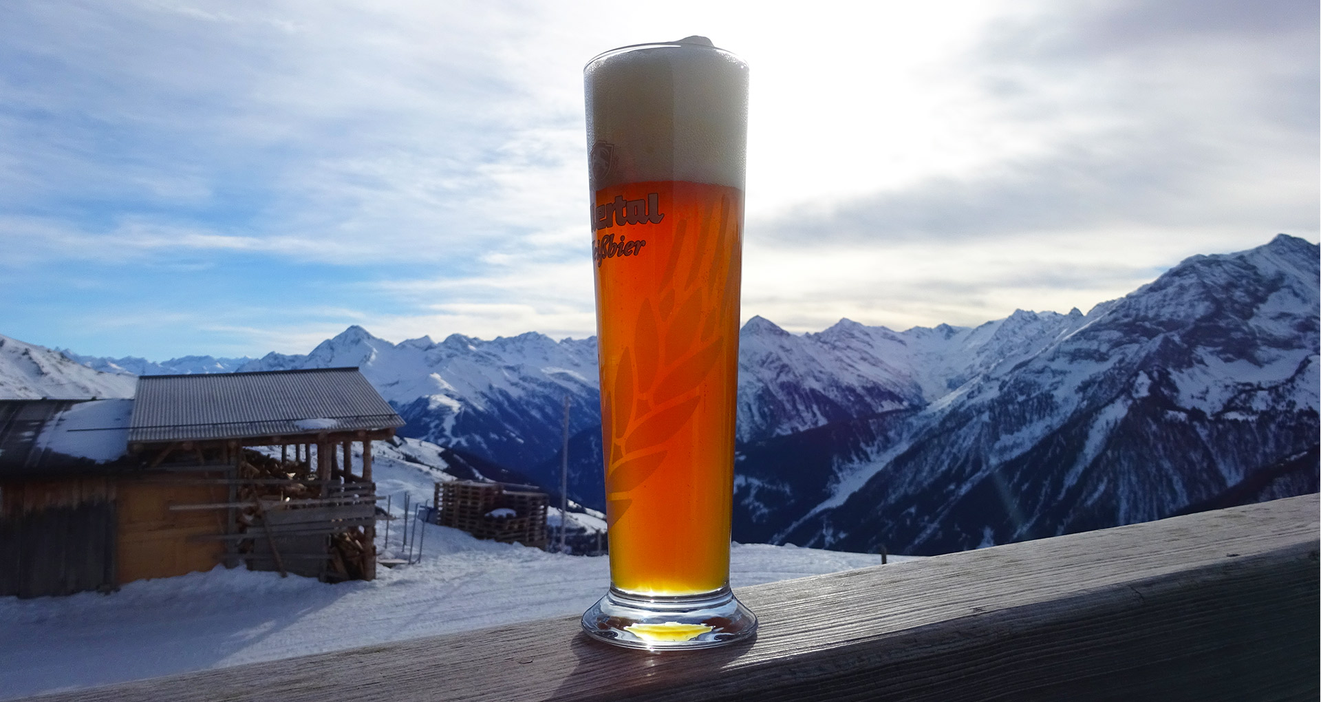 Pint of beer in front of snowy mountains