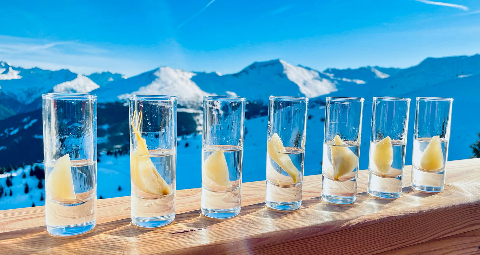 Shots of schnapps in front of snowy mountains