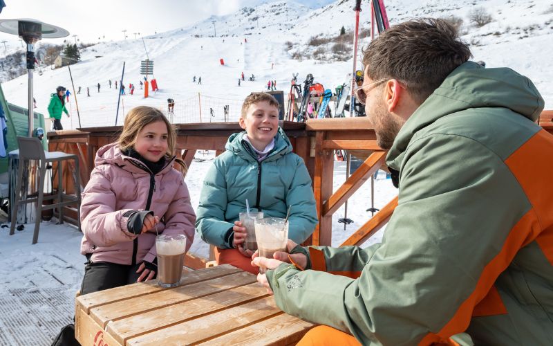 Family taking a break from the slopes drinking hot chocolate